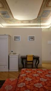 ボローニャにあるCasa Isolani Piazza Maggiore 1.0のベッド、デスク、テーブルが備わる客室です。