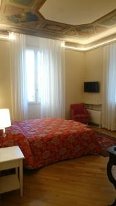 ボローニャにあるCasa Isolani Piazza Maggiore 1.0のベッドルーム1室(赤毛布、窓付)