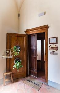 a hallway with a wooden door with plants on it at B&B L'Agnolo Di Caroti Cinzia in Montepulciano