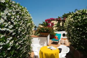 a yellow table and chairs on a patio with flowers at Hotel Villa Angelica in Ischia
