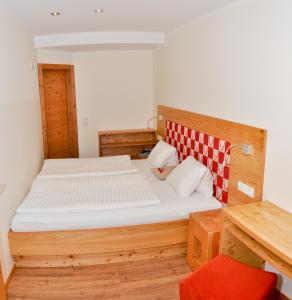ゾンネンアルペ・ナスフェルトにあるSölle Homes Nassfeldのベッドルーム1室(木製ベッド1台、木製テーブル付)
