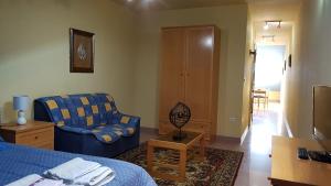 Habitación con cama, sofá y silla en Apartamento Ático Select Real Caldas de Reis, en Caldas de Reis