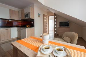a kitchen with a table with two cups of coffee on it at Fajne Apartamenty - Karwia - Blisko Plaży - Komfort i Cisza in Karwia