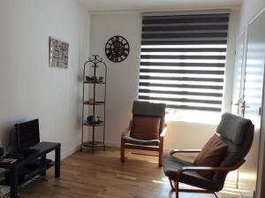 a living room with two chairs and a window with blinds at Number 7 Gouarec in Gouarec
