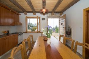 a kitchen with a wooden table with a vase of flowers on it at Stiniva-stone House in Vela Luka