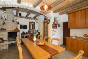 a kitchen and dining room with a wooden table and a fireplace at Stiniva-stone House in Vela Luka