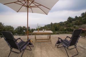 two chairs and a table with an umbrella at Stiniva-stone House in Vela Luka +22 photos