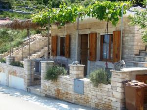 a stone house with trees on the side of it at Stiniva-stone House in Vela Luka