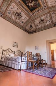 een slaapkamer met een bed en 2 stoelen en een plafond bij B&B L'Agnolo Di Caroti Cinzia in Montepulciano