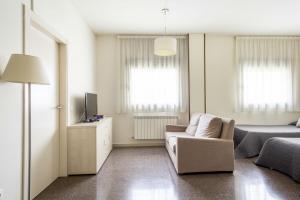 ein Wohnzimmer mit einem Sofa und einem TV in der Unterkunft Residencia Universitaria Los Abedules in Pamplona