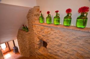 a group of green bottles sitting on top of a stone fireplace at Casa Rural Caseta de l' Hort in Villafranca del Cid
