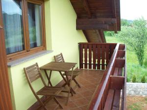 a patio with two chairs and a table on a balcony at House Mara in Korenica
