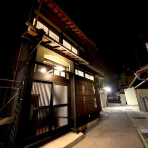 una entrada a un edificio con una puerta por la noche en Utatei, en Takayama