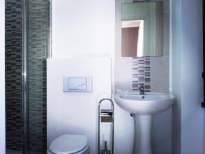a bathroom with a sink and a toilet and a mirror at PORRINO Guest House - Affittacamere in Alghero +24 photos