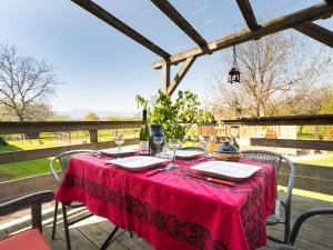 a table with a red table cloth on a patio at Au pré des Poulains in Ostheim +17 photos
