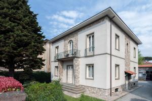 - un bâtiment blanc avec un balcon et un arbre dans l'établissement Lucca In Villa Elisa & Gentucca, à Lucques