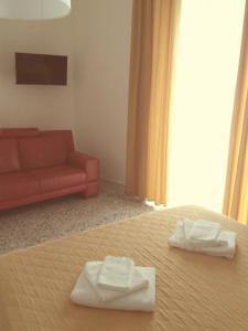 ein Schlafzimmer mit einem Bett und einer roten Couch in der Unterkunft Casa Fiore in Neapel
