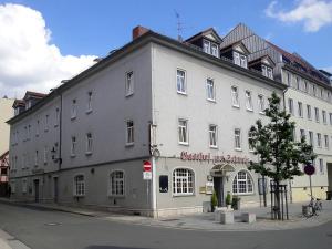 ein großes graues Gebäude an der Ecke einer Straße in der Unterkunft Gasthof zur Schweiz in Jena