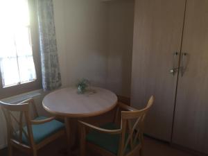 ein kleiner Tisch und Stühle in einem Zimmer mit Fenster in der Unterkunft Lotus Garden in Gailingen