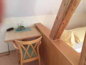 ein kleiner Tisch und ein Hocker neben einem Bett in der Unterkunft Lotus Garden in Gailingen