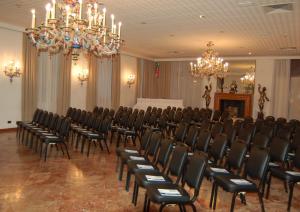 une salle de conférence avec des chaises et un lustre dans l'établissement Astoria Hotel Italia, à Udine