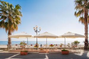 ディアーノ・マリーナにあるHotel Tinaの浜辺の傘を持つテーブル