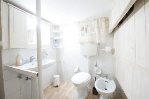 Un baño blanco con inodoro y lavabo. en La Cutizza B&B, en Martina Franca 47 fotos más