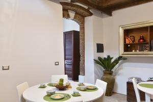 uma sala de jantar branca com uma mesa e cadeiras brancas em B&B Villa Grazia em Pagliara