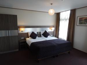 a hotel room with a bed and a window at Hotel Faber in Hoogezand