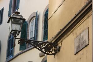 a street light attached to the side of a building at Assaporarte in Florence