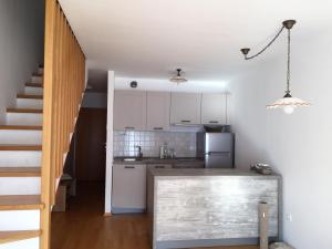une petite cuisine avec des placards blancs et un escalier dans l'établissement Apartment MANCA-HOLIN, à Bohinj