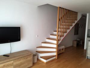 Il comprend un salon avec un escalier et une télévision. dans l'établissement Apartment MANCA-HOLIN, à Bohinj