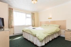 a bedroom with a large bed and a television at The Glendeveor in Newquay