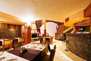 un restaurante con mesas y sillas y una pared de piedra en Family Hotel Ogi, en Asenovgrad