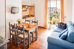 ein Wohnzimmer mit einem Tisch und einem blauen Sofa in der Unterkunft Il Borgo Della Rovere in San Bartolomeo al Mare