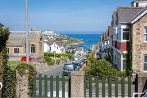a view of a street with houses and the ocean at The Glendeveor in Newquay