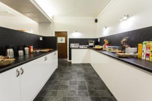 a kitchen with a stove, sink, and cabinets at The Glendeveor in Newquay