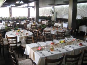 a dining room with white tables and chairs at Neptune Hotel in Saints Constantine and Helena