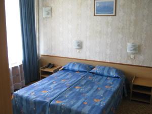a bedroom with a bed with a blue comforter at Neptune Hotel in Saints Constantine and Helena +8 photos