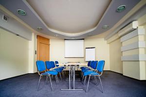 a conference room with a table and blue chairs at Hotel Polski in Mielec