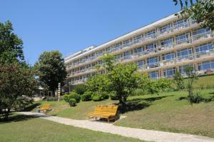 a building with benches in front of a building at Neptune Hotel in Saints Constantine and Helena