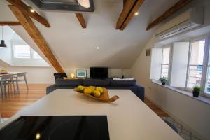 Apartment Grazioso في دوبروفنيك: غرفة معيشة مع طاولة مع وعاء من الفواكه عليها