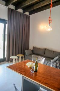 ein Wohnzimmer mit einem Tisch und einer Flasche Wein in der Unterkunft Rena Village in Rena Majore
