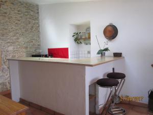 a kitchen with a counter and two stools at Au carrefour Vallée de la Cèze in Bagnols-sur-Cèze
