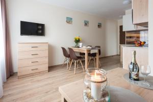 a living room with a table and a kitchen with a dining room at Fajne Apartamenty - Karwia - Blisko Plaży - Komfort i Cisza in Karwia