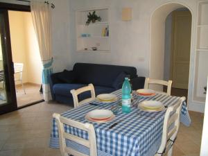 a dining room table with a blue and white checkered table cloth at Al mare in Sardegna in Porto San Paolo