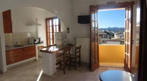 a kitchen with a table and a kitchen with a view at Mantraki Hotel Apartments in Agios Nikolaos