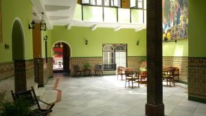 a dining room with green walls and tables and chairs at Al Andalus Jerez in Jerez de la Frontera