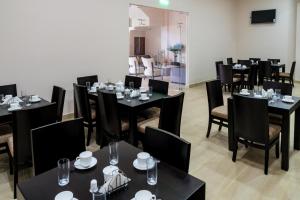 a dining room with black tables and black chairs at Hotel La Ría Durán in Durán
