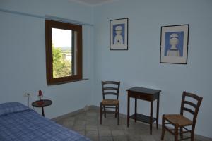 a bedroom with a bed and a table and chairs at Podere S.Giulia - casale Banditelle in Venturina Terme